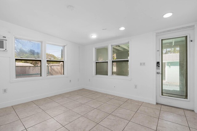 spare room featuring crown molding, wood finished floors, baseboards, and a wall mounted AC