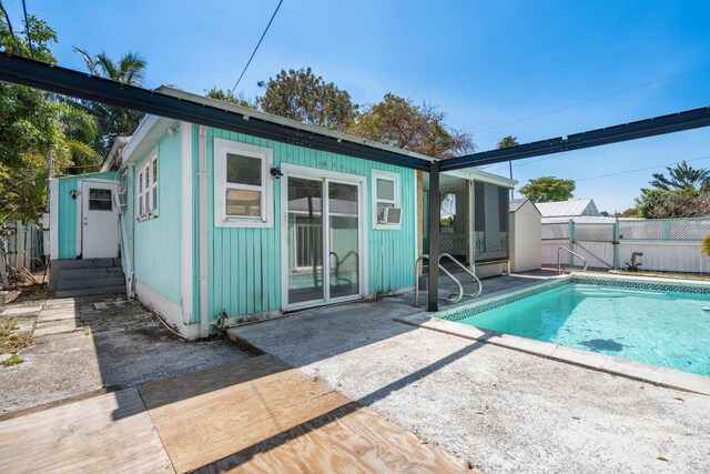 back of house with a patio, fence, a fenced in pool, and an outbuilding