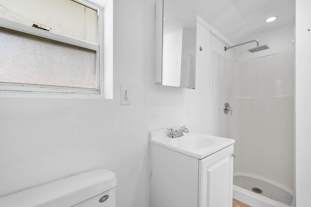 full bathroom with visible vents, vanity, toilet, and a shower stall