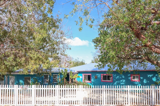 ranch-style house with metal roof and a fenced front yard