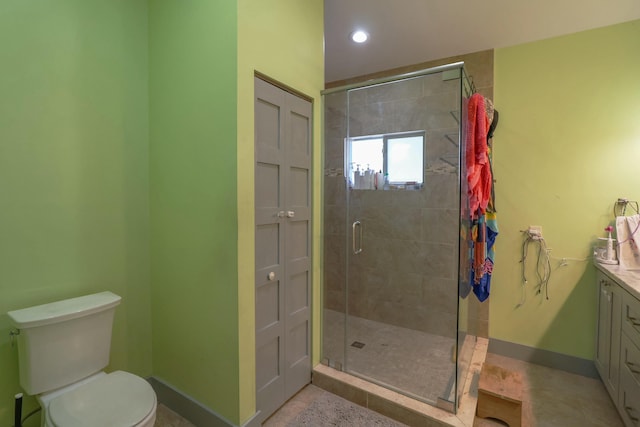 bathroom featuring a stall shower, baseboards, vanity, and toilet