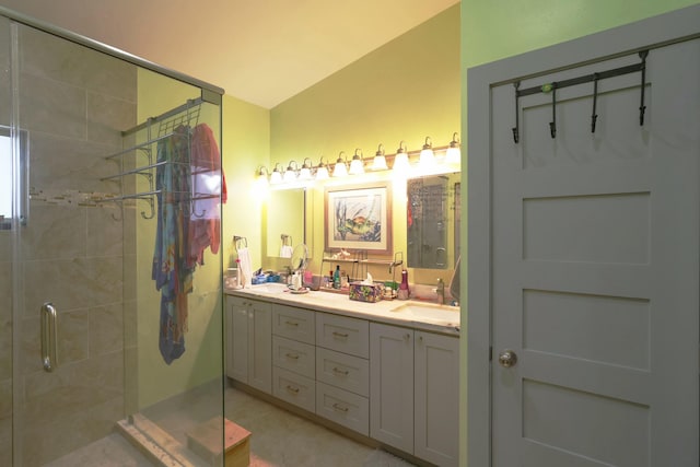 full bathroom featuring a stall shower, double vanity, and lofted ceiling
