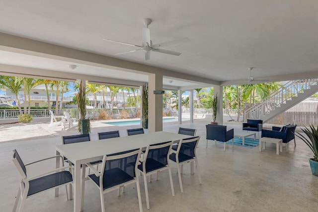 view of patio / terrace featuring a fenced in pool, ceiling fan, stairway, fence, and outdoor dining space