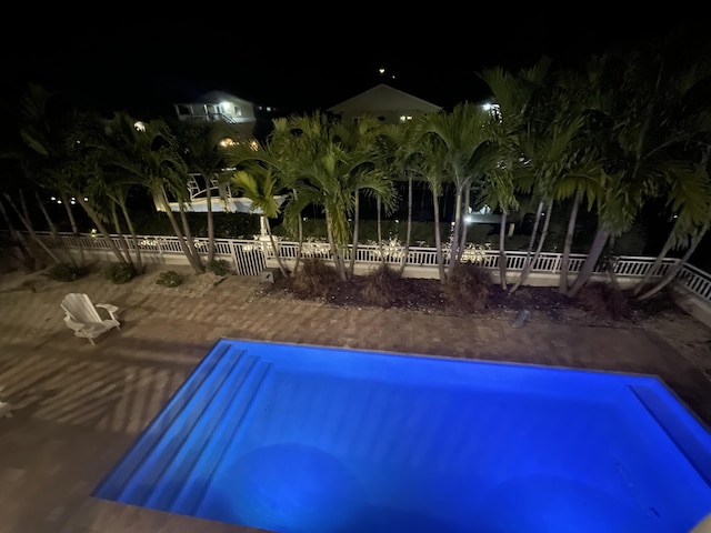 pool at twilight featuring fence