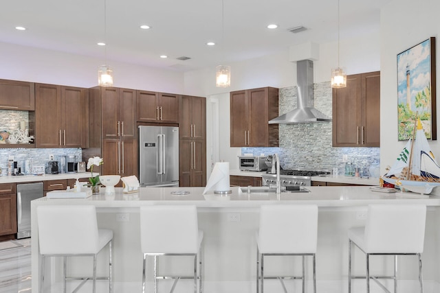 kitchen featuring high end fridge, light countertops, visible vents, and wall chimney exhaust hood