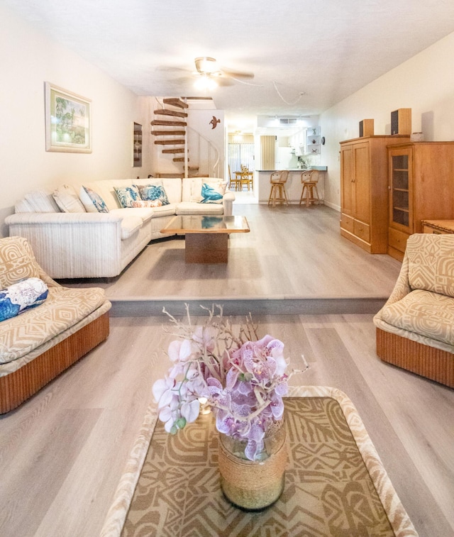 living room with wood-type flooring and ceiling fan