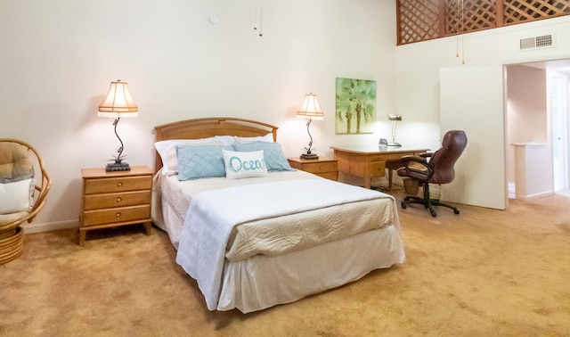 bedroom featuring light carpet and a high ceiling