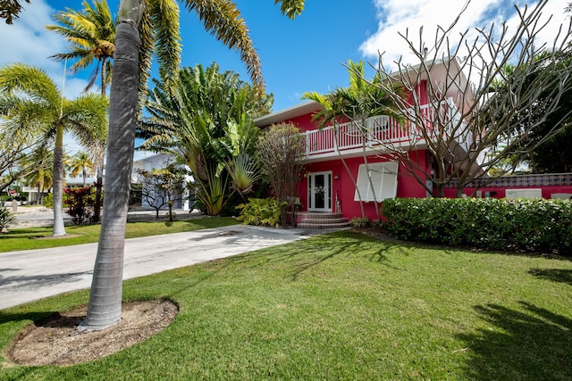 view of front of home with a front yard and a balcony