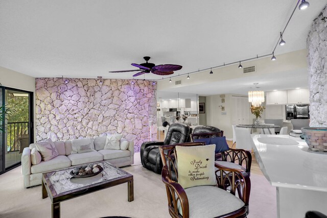living room with ceiling fan with notable chandelier