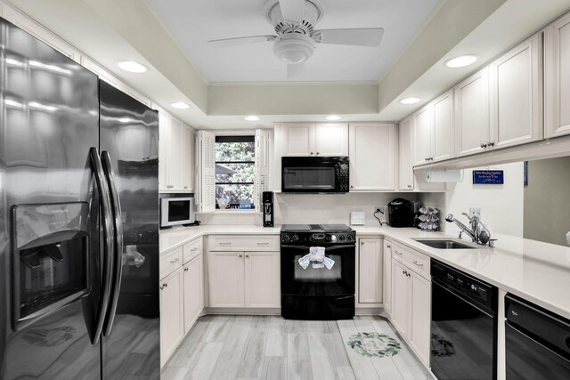 kitchen featuring sink, ceiling fan, black appliances, light hardwood / wood-style floors, and white cabinets
