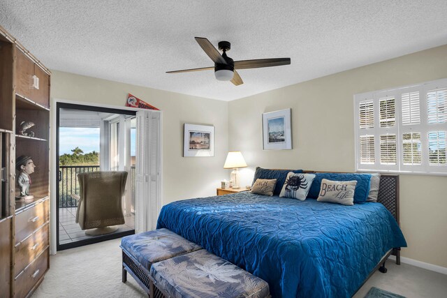 bedroom with light carpet, access to exterior, and a textured ceiling