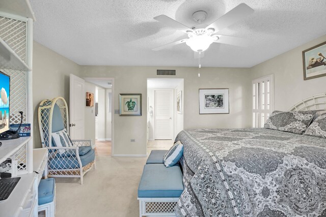 carpeted bedroom with ceiling fan and a textured ceiling