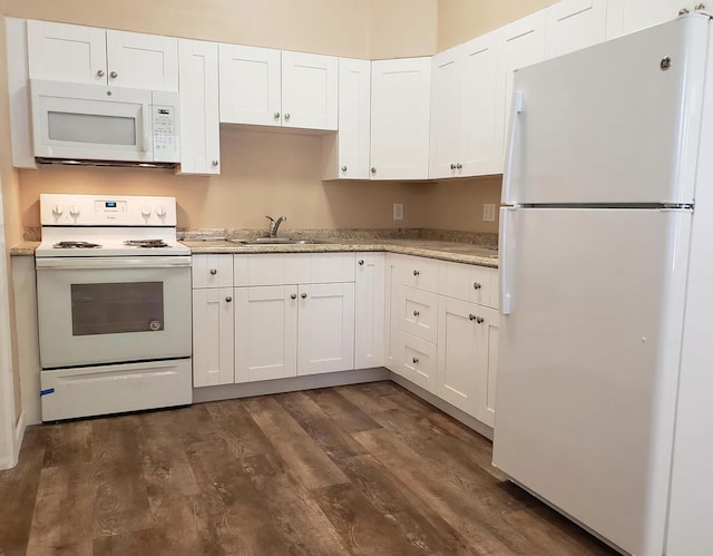 kitchen with a sink, white cabinets, white appliances, and dark wood-style flooring