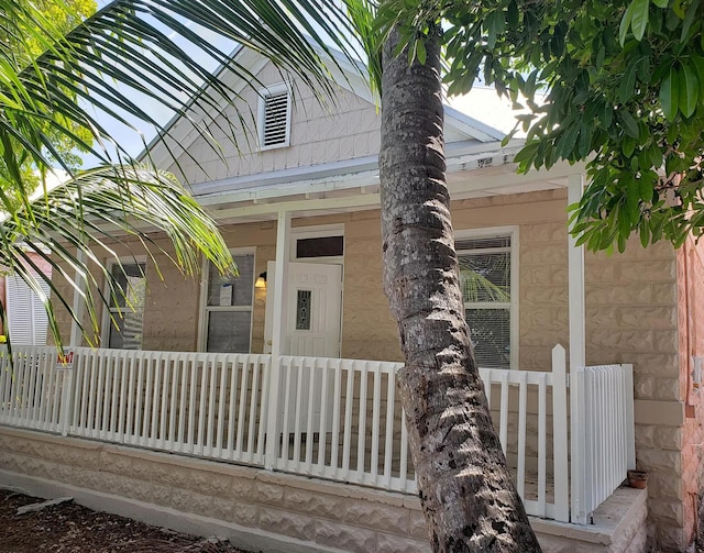 view of exterior entry with visible vents and covered porch