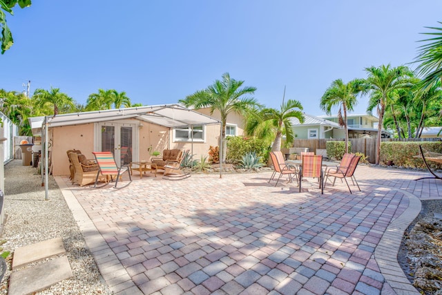view of patio with an outdoor hangout area, outdoor dining area, french doors, and a fenced backyard