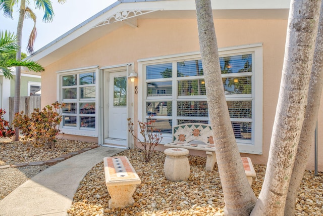 exterior space featuring stucco siding and fence