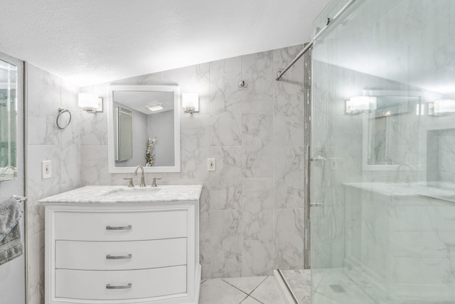 full bathroom featuring vanity, a textured ceiling, and a marble finish shower
