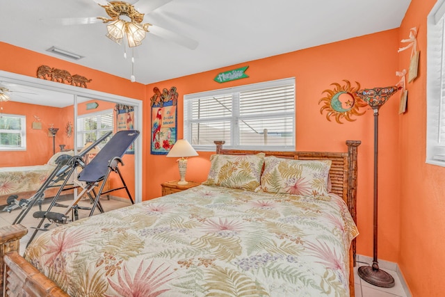 tiled bedroom with visible vents, baseboards, and a ceiling fan