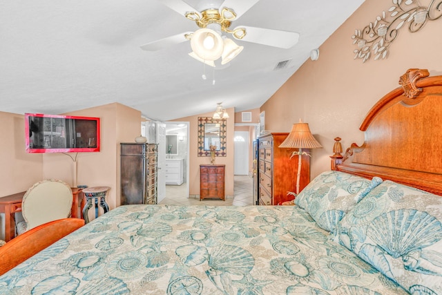 bedroom with ensuite bath, tile patterned floors, visible vents, and vaulted ceiling