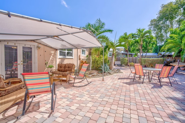 view of patio / terrace with french doors, outdoor dining space, fence, and an outdoor living space