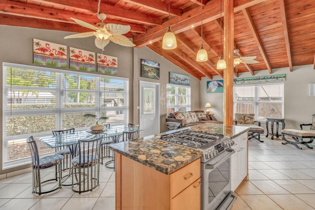 kitchen featuring stainless steel gas range, ceiling fan, light tile patterned flooring, and wooden ceiling