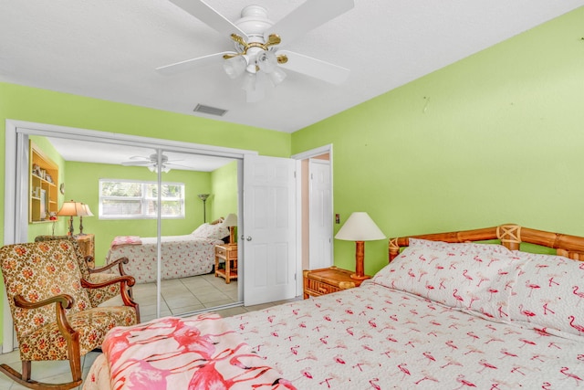 tiled bedroom featuring a closet, a ceiling fan, and visible vents