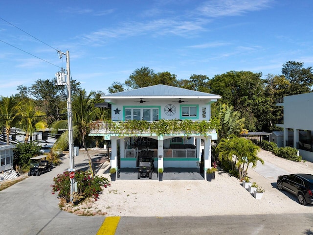 beach home featuring a balcony and ceiling fan