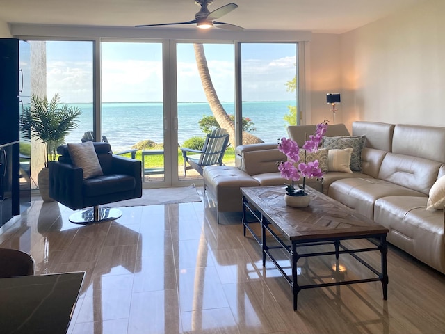 living room with a water view and ceiling fan