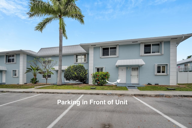 40 High Point Rd Unit C105, Tavernier, FL 33070 - view of property with uncovered parking, stucco siding, and a metal roof