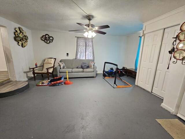 living room with ceiling fan, concrete floors, and a textured ceiling