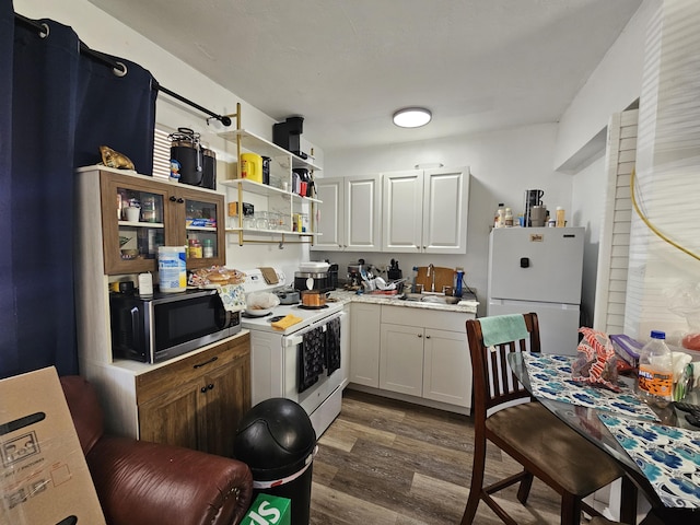 kitchen featuring white cabinetry, sink, white appliances, and dark wood-type flooring