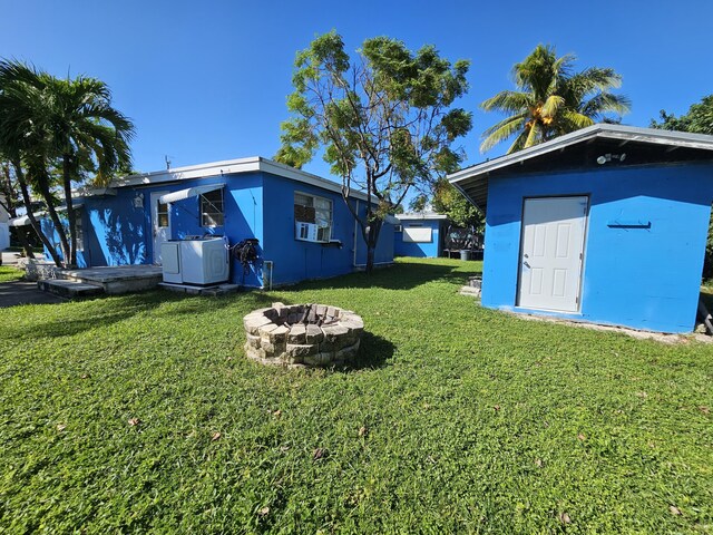 view of yard featuring cooling unit and a fire pit