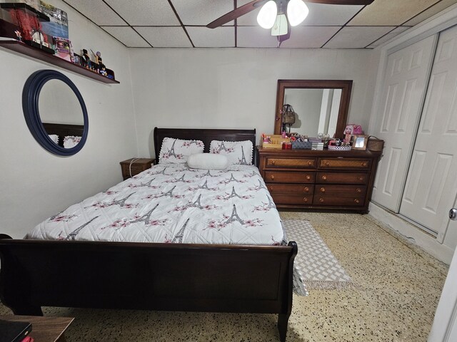 bedroom featuring a drop ceiling, a closet, and ceiling fan