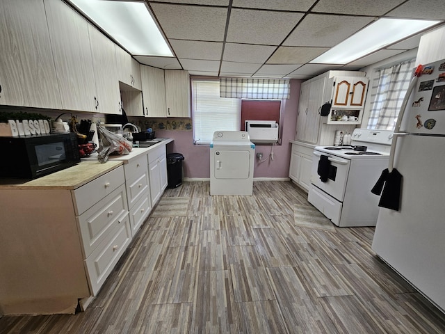 kitchen with white appliances, washer / dryer, light hardwood / wood-style floors, and a kitchen island