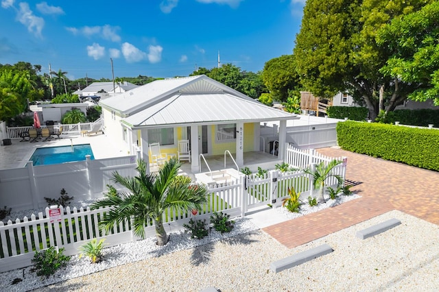 bungalow-style home with a fenced in pool and a patio