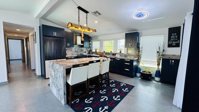 18 W Circle Dr, Saddle Bunch, FL 33040 - kitchen featuring fridge, tasteful backsplash, light stone counters, a kitchen island, and decorative light fixtures