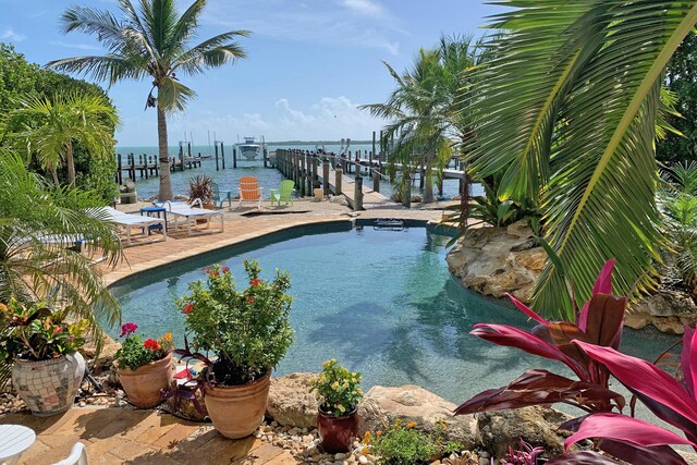 view of pool featuring a water view and a boat dock