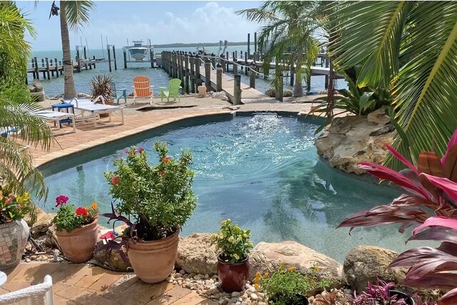 view of pool with a dock and a water view