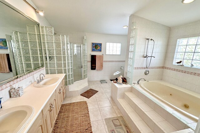 bathroom with tile walls, tile patterned flooring, vanity, vaulted ceiling, and independent shower and bath