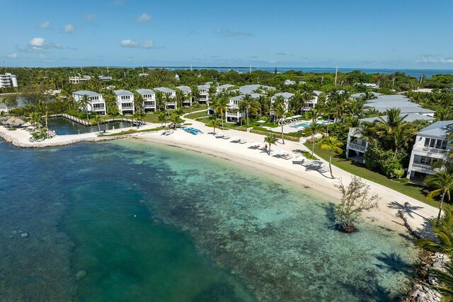 drone / aerial view featuring a beach view and a water view