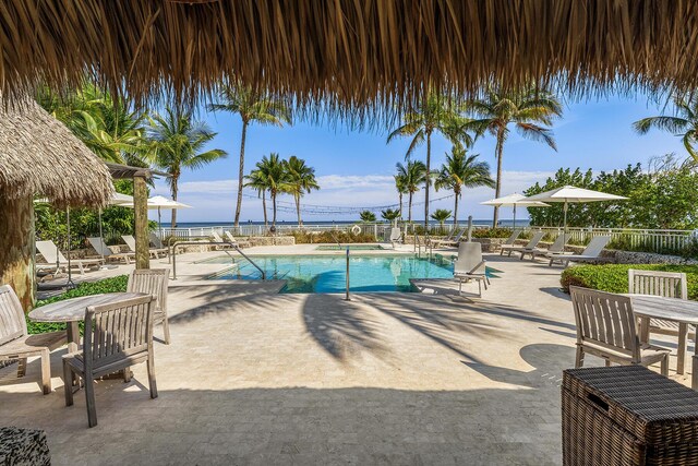 view of pool featuring a water view and a patio area