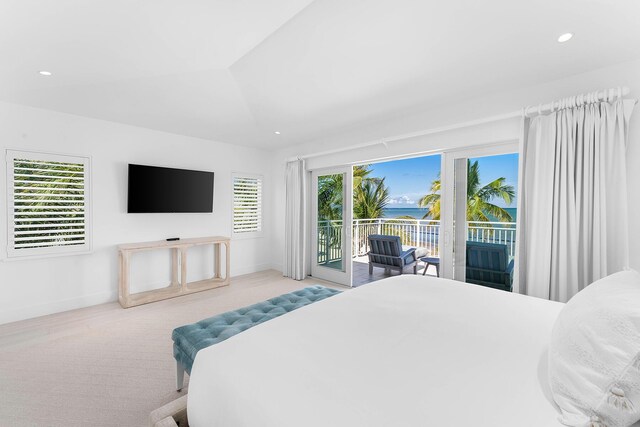 bedroom featuring lofted ceiling, access to exterior, and light colored carpet