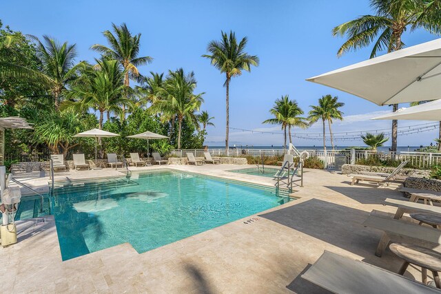 view of pool with a patio and a water view