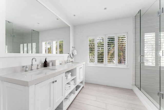 bathroom with hardwood / wood-style flooring, vanity, and an enclosed shower