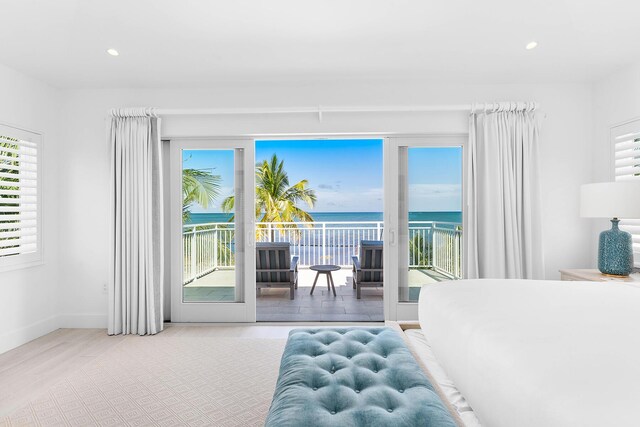 bedroom with a water view and access to exterior