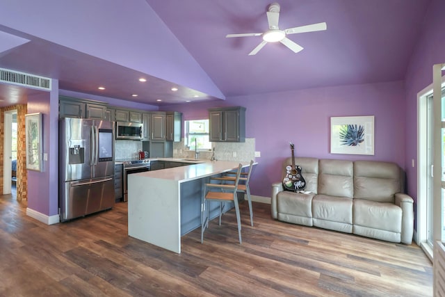 112 Gardenia St, Tavernier, FL 33070 - kitchen with appliances with stainless steel finishes, a peninsula, vaulted ceiling, a sink, and a breakfast bar