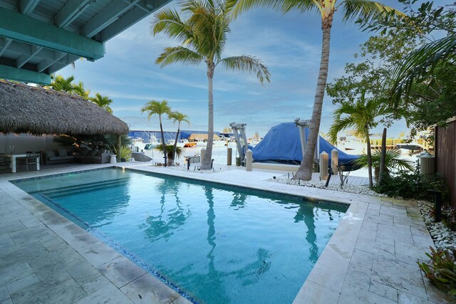 112 Gardenia St, Tavernier, FL 33070 - outdoor pool with boat lift, a dock, a gazebo, and a patio area