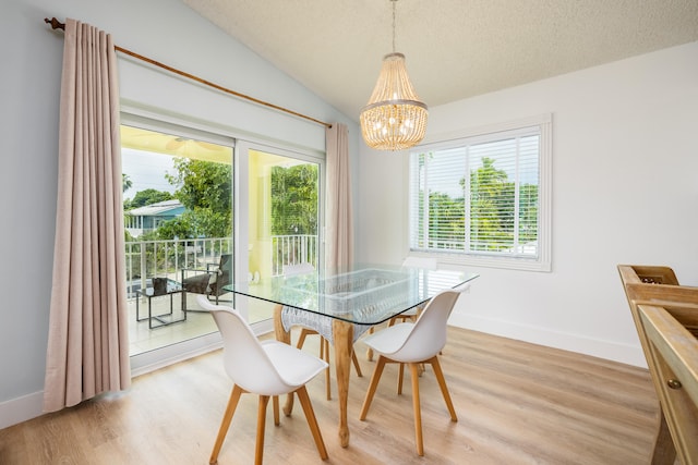 dining room with vaulted ceiling, light hardwood / wood-style floors, a chandelier, and a healthy amount of sunlight