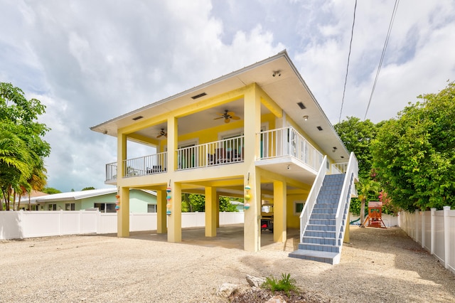 rear view of property featuring a playground and ceiling fan