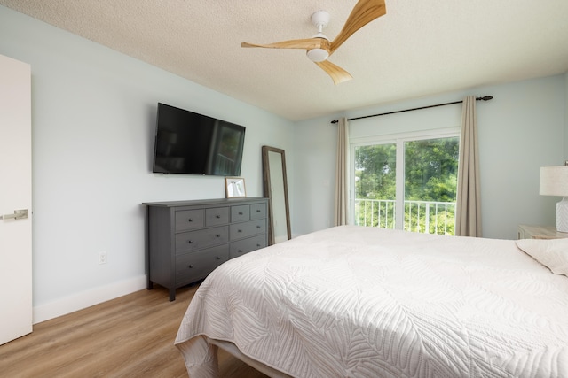 bedroom with ceiling fan, light hardwood / wood-style floors, a textured ceiling, and access to outside